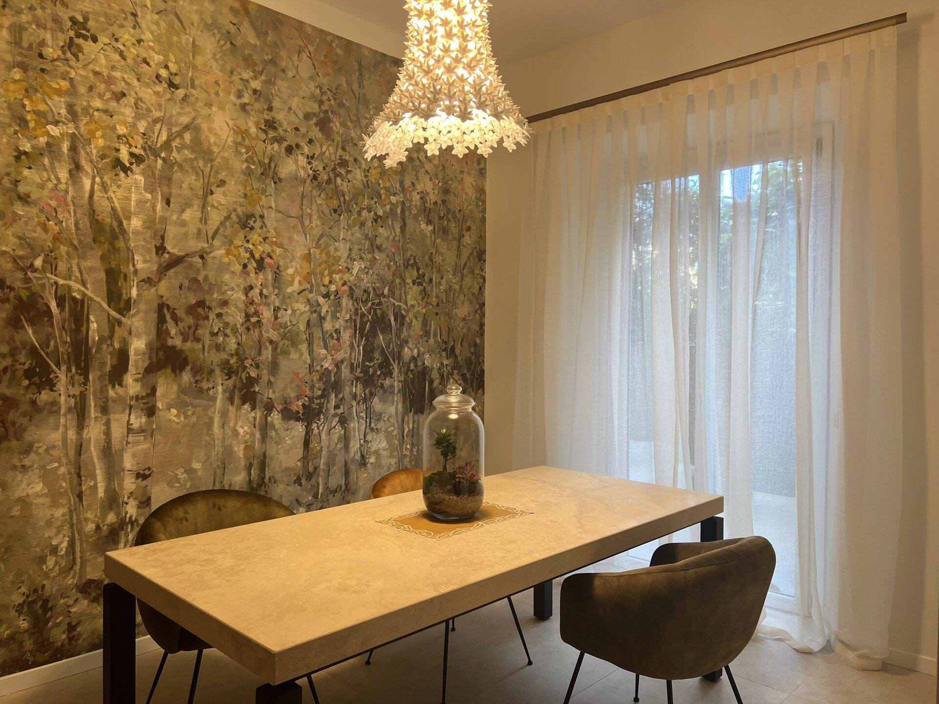 Sala da pranzo con carta da parati panoramica a bosco e tenda in lino, progetto Zefiro Interiors