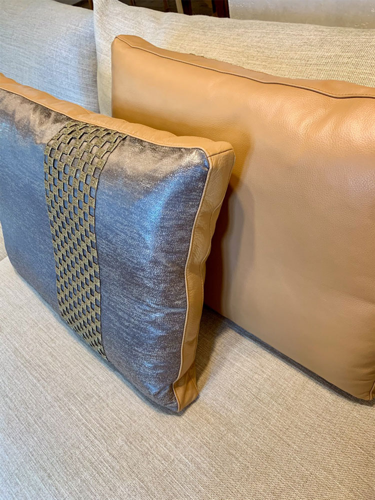 The leather and fabric cushions decorated with a border made by Houlès Paris